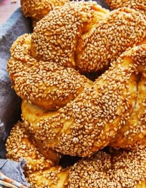 a close up of a baked simit dough ring in a basket.