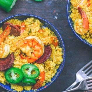 An overhead photo of shrimp couscous and 2 forks next to another bowl of the shrimp couscous.